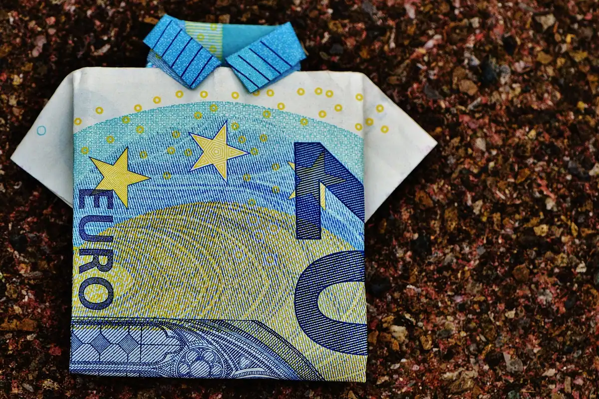Bancnote de euro împăturite, pe un fundal simplu, ilustrând banii lichizi și rezervele