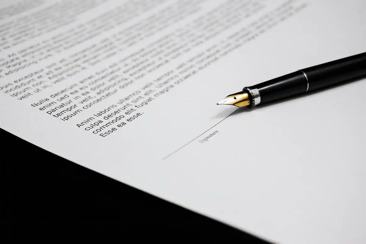 Stilou așezat pe un contract tipărit, lângă rubrica de semnătură, la verificarea marjei