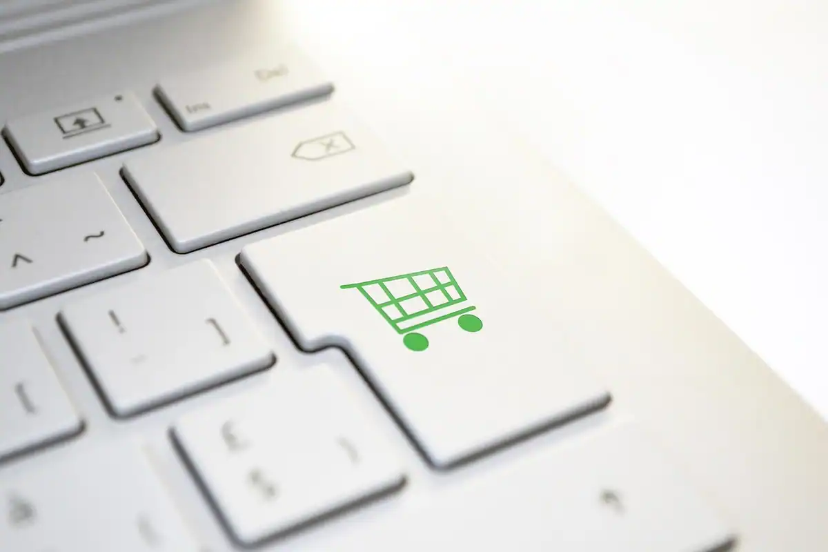 Tastă de tastatură cu un coș de cumpărături verde, simbol al ratelor la magazin online