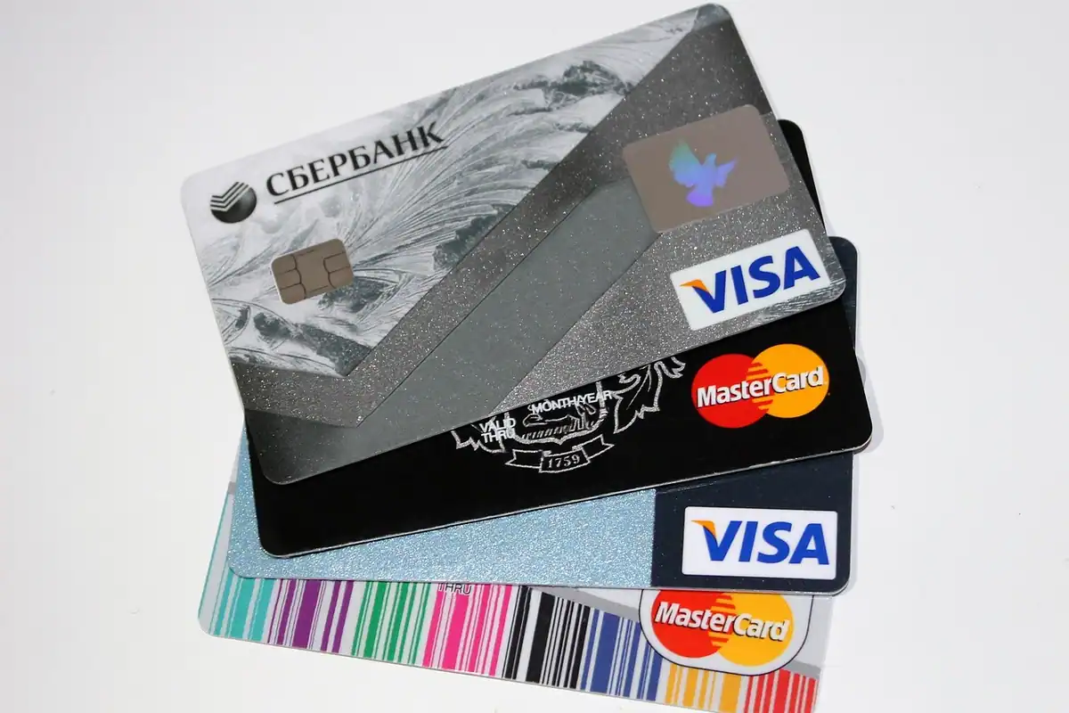 Mai multe carduri bancare de credit, așezate unul peste altul pe o masă